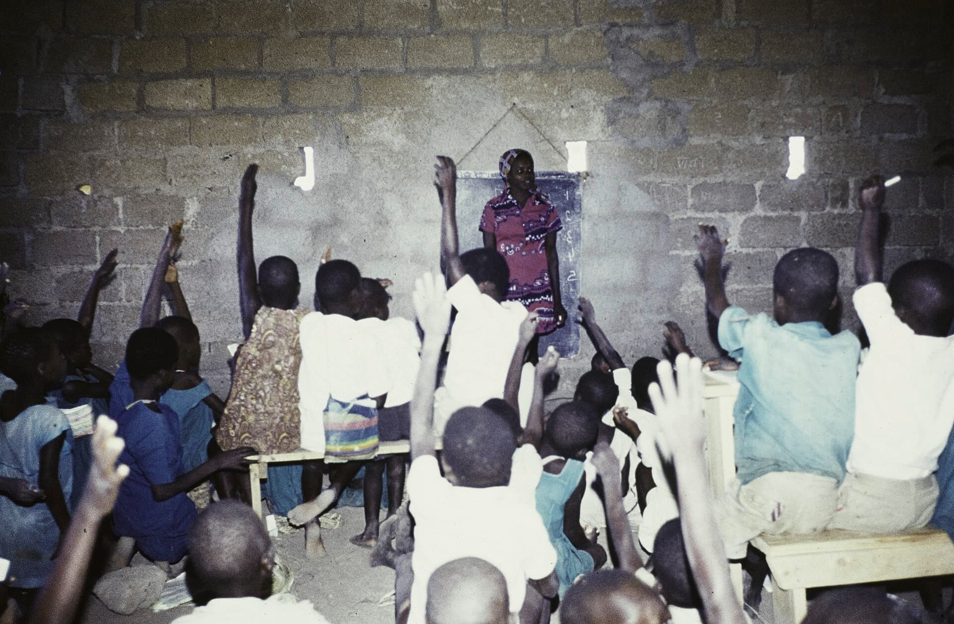 Pupils raising their hands to answer a question in class