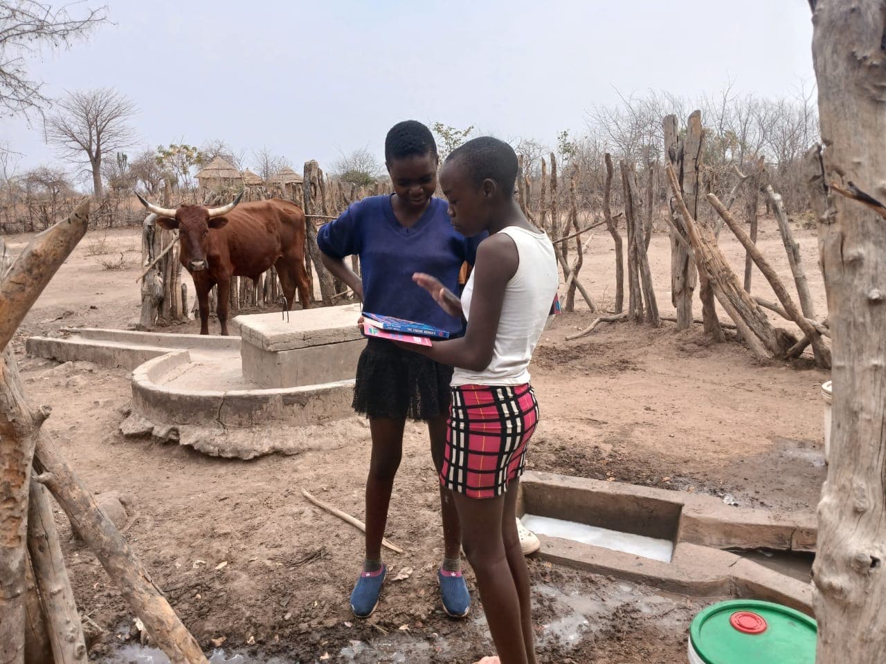 Two participants beside a cattle enclosure and water trough