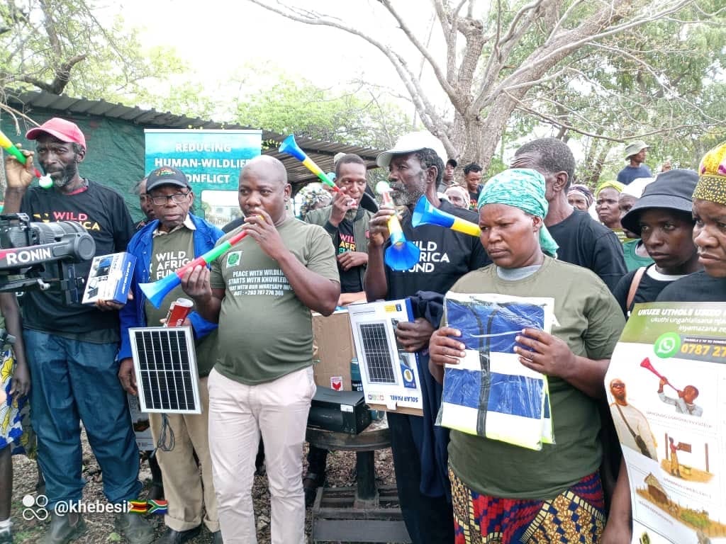 Community members displaying solar equipment and coexistence materials