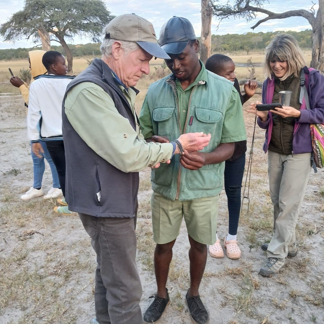 Participants examining an item together outdoors