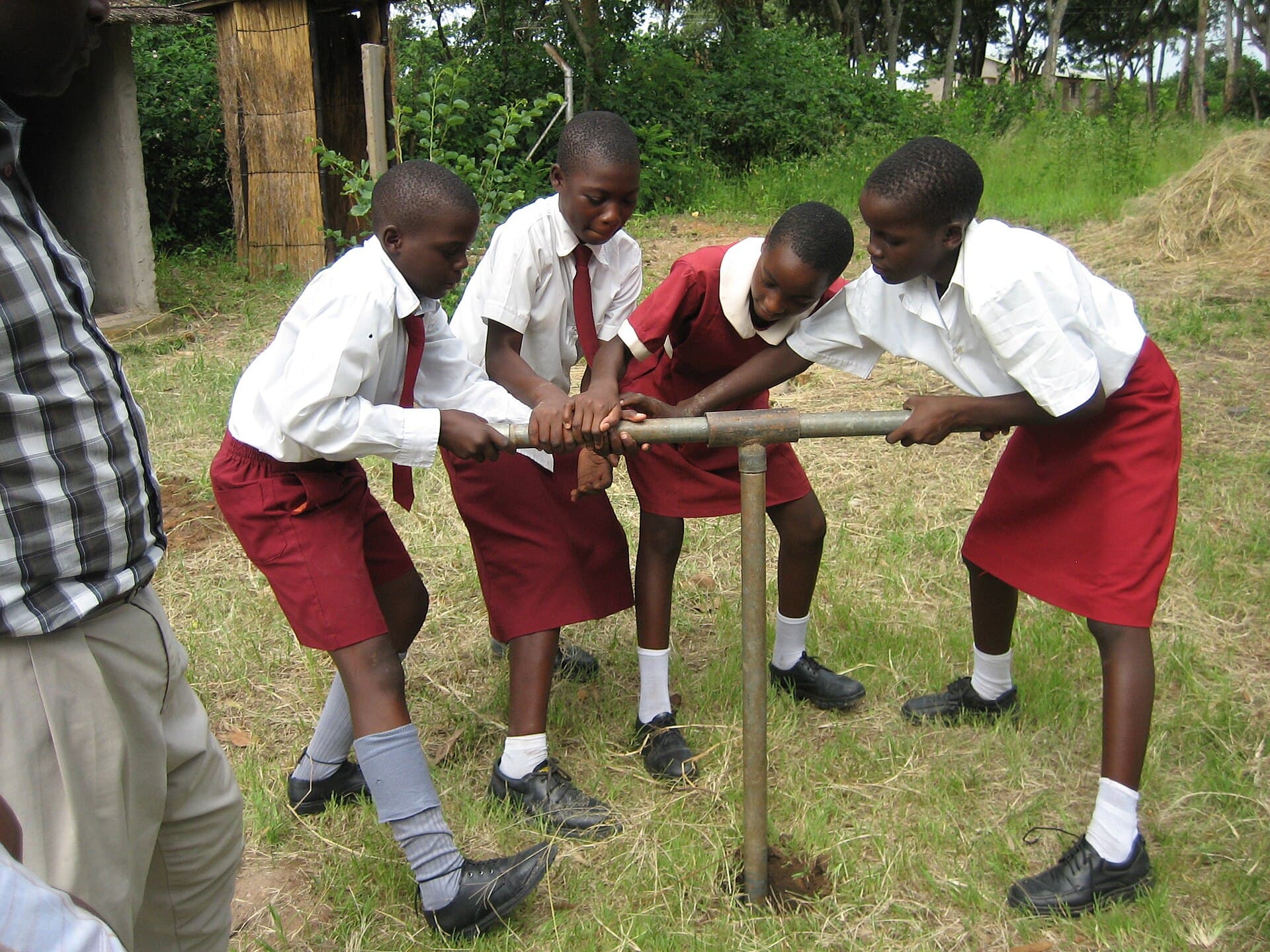 School students augering a hole for tree planting in Zimbabwe